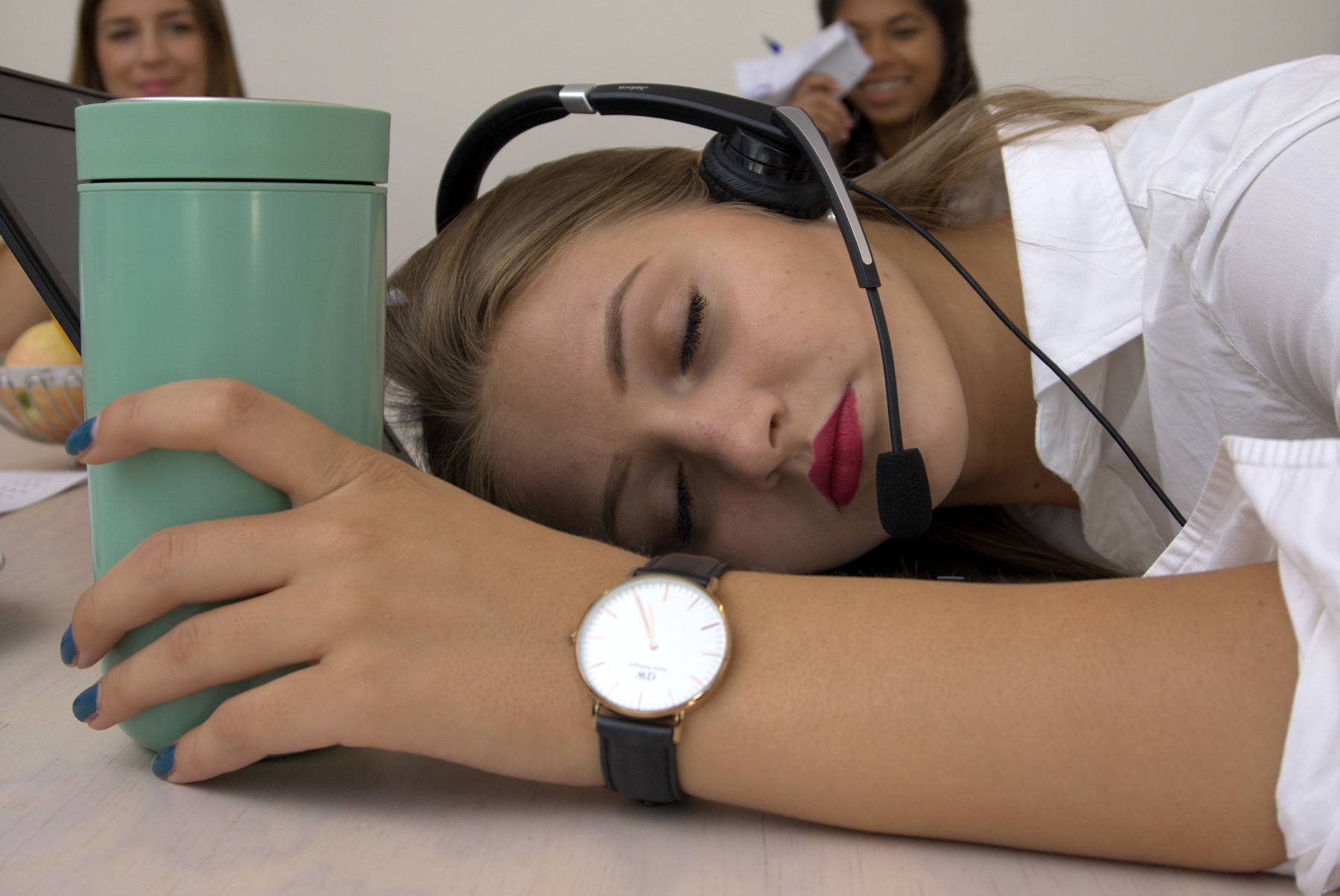 Junge Frau schläft mit Headset auf ihrem Laptop