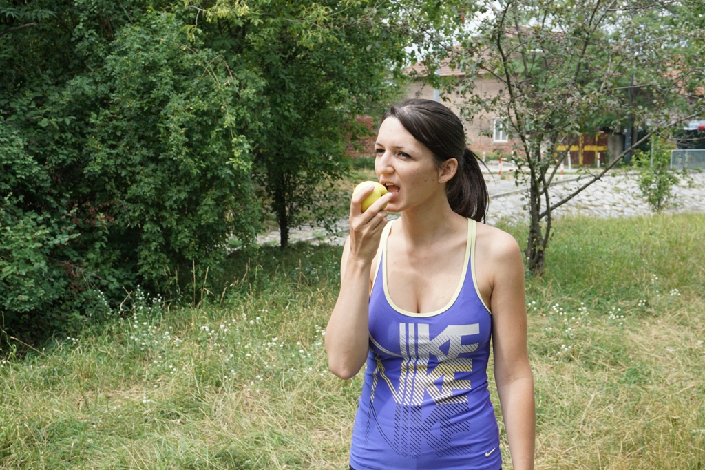 Frau isst einen Apfel / Vitamine nach dem Sport