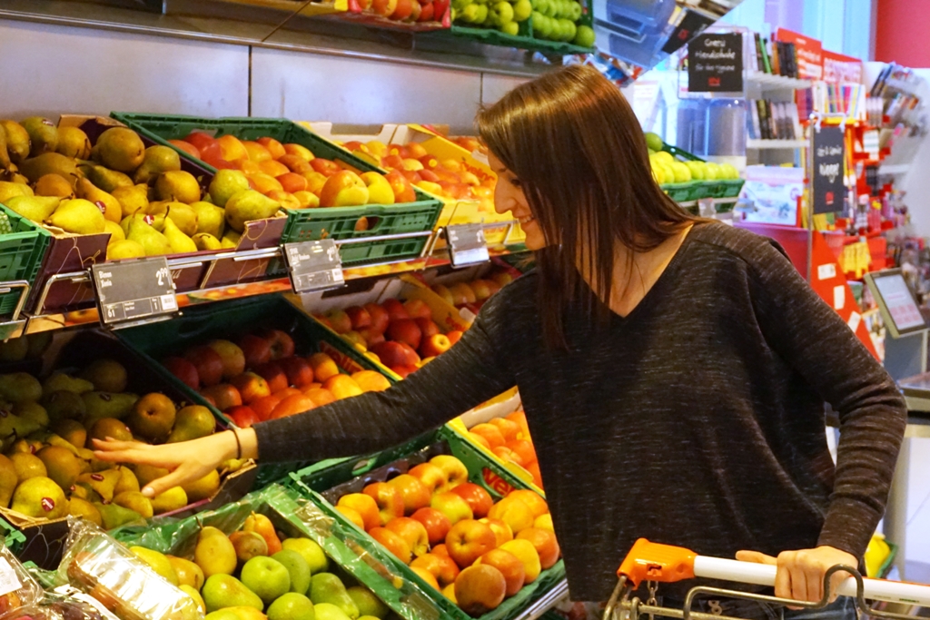 Junge Frau kauft frisches Obst