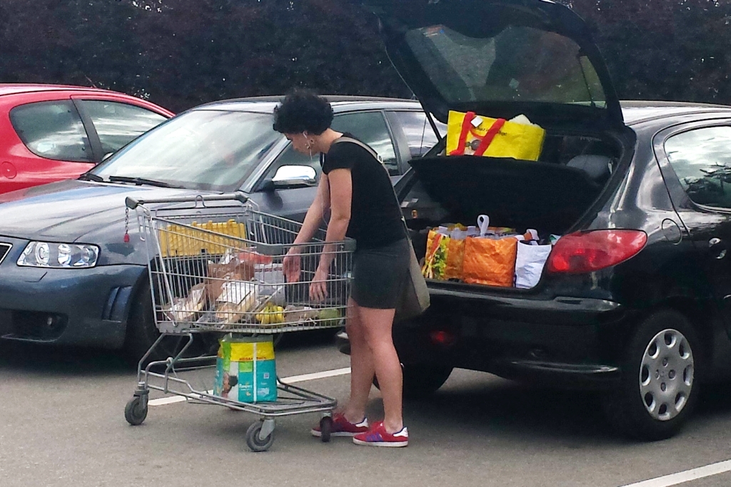 Frau räumt Einkäufe in das Auto