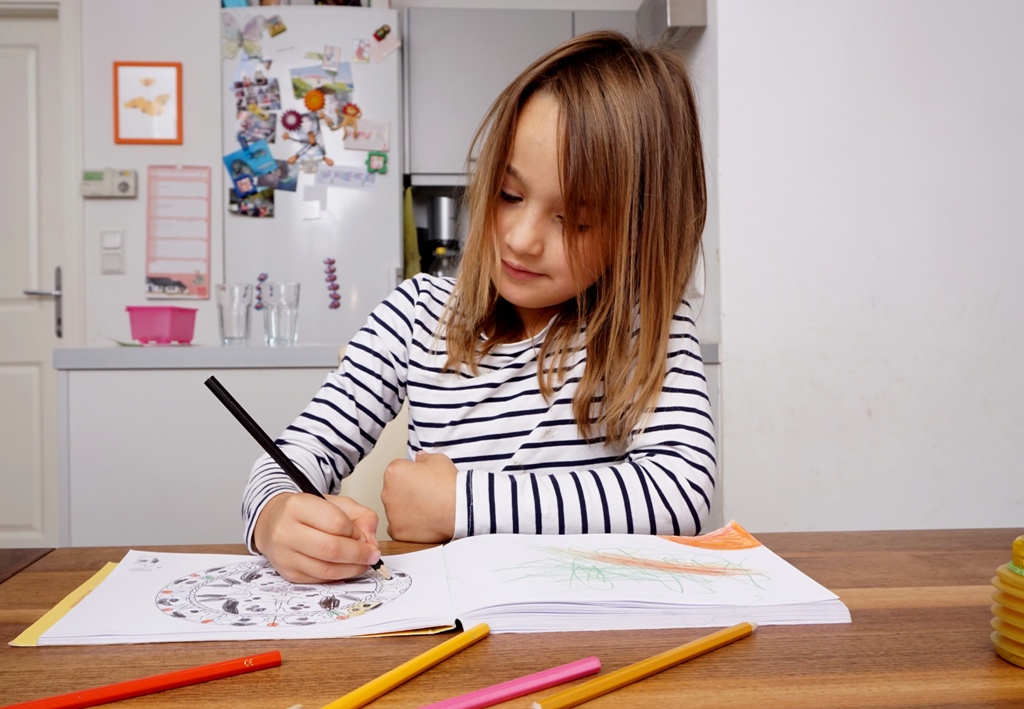 Kind malt in einem Malbuch