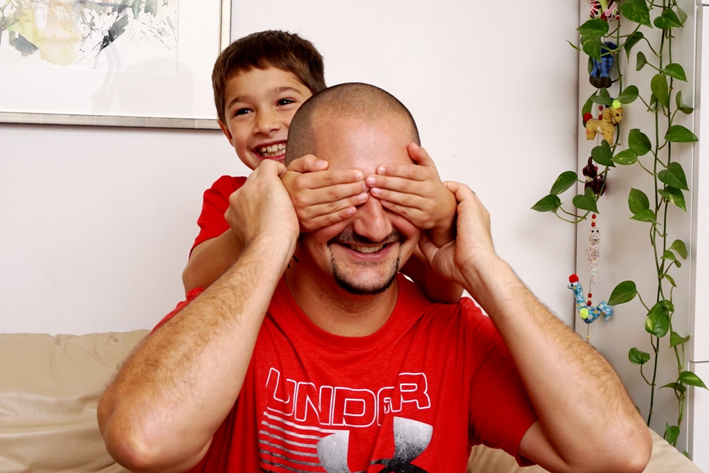 Kind hält Papa Augen und Ohren zu
