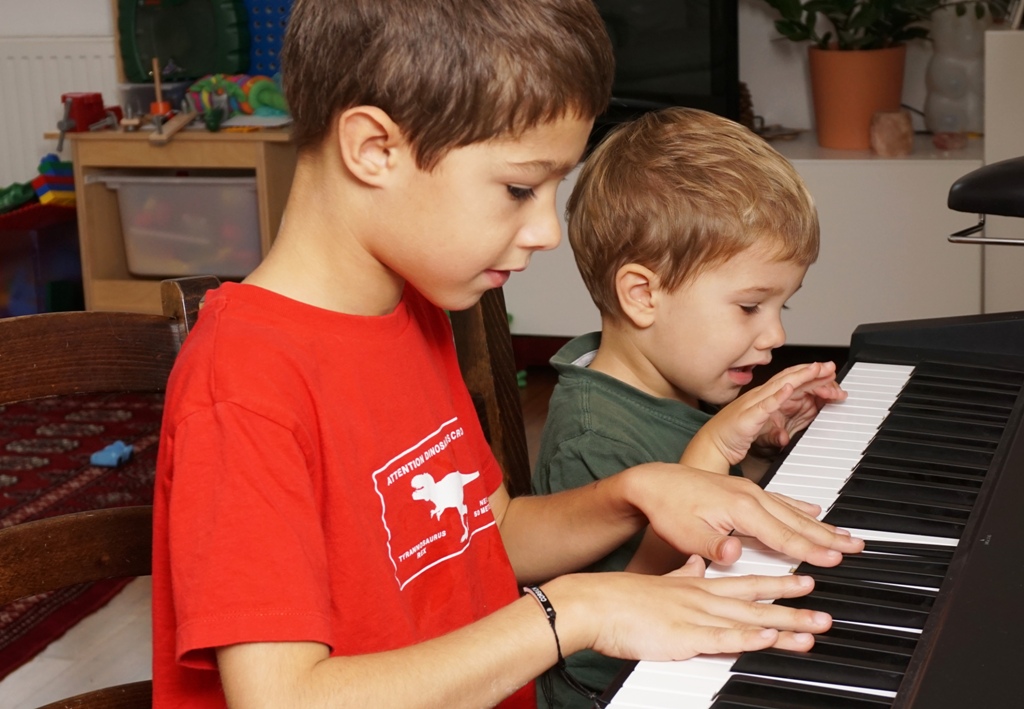 Kinder spielen gemeinsam Klavier