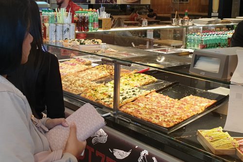 Pizzastand Frau kauft Pizza