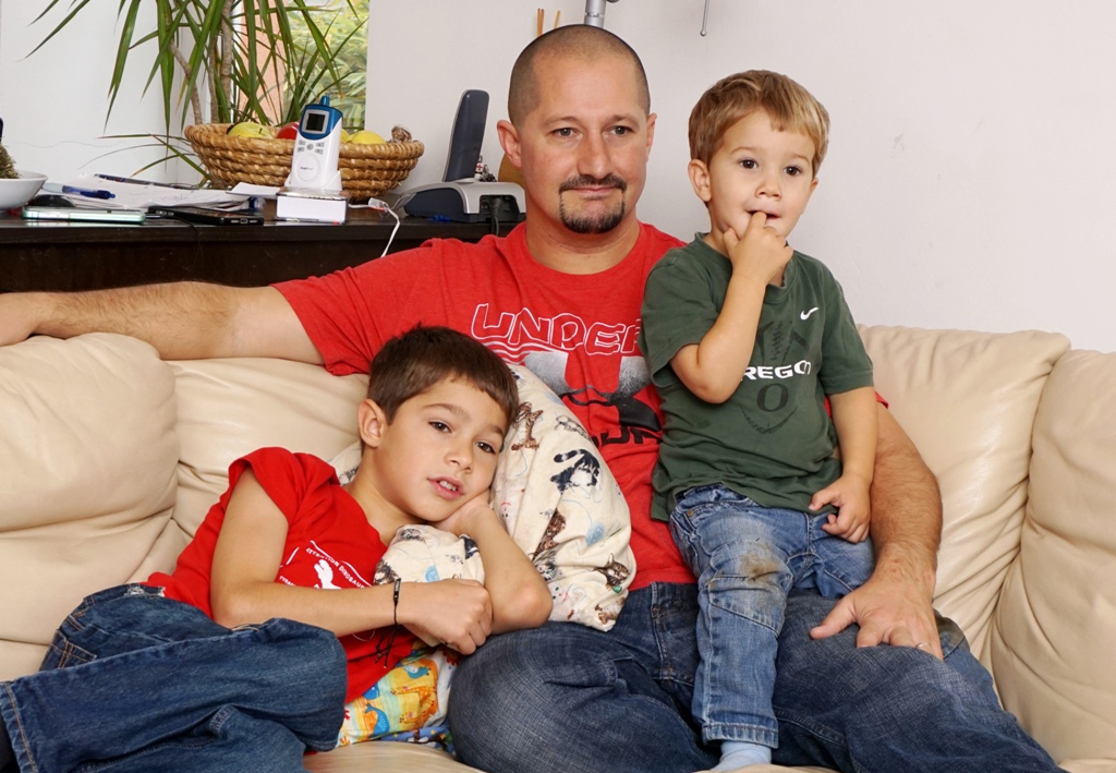 Vater und Kinder sitzen auf einer Couch
