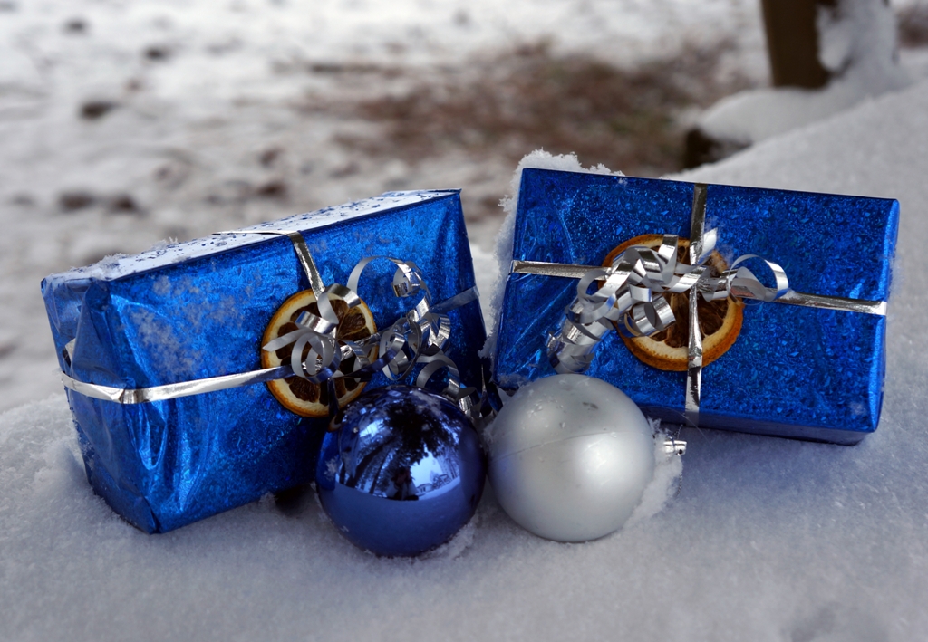 Weihnachtskugeln und Geschenke liegen im Schnee