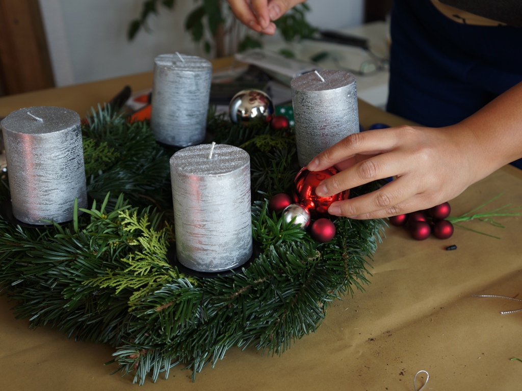 Adventskranz basteln 11/18: Der Schmuck wird zur Probe auf den Kranz gelegt